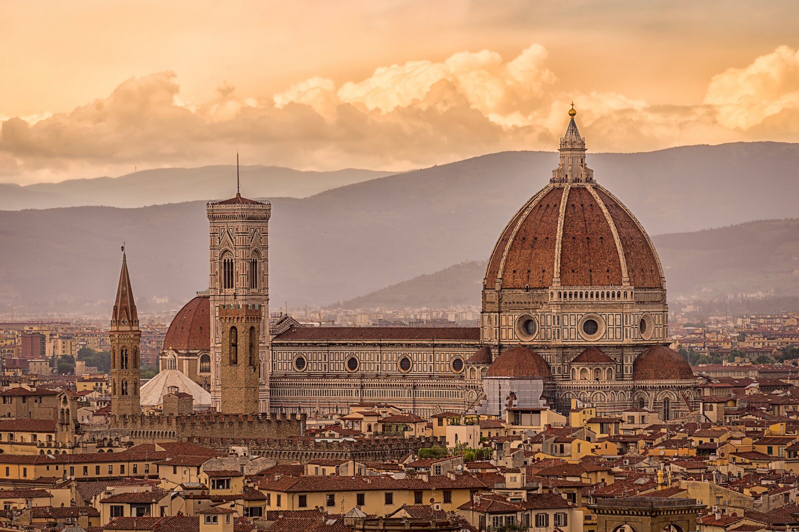 Panorama Florencie s kupolí katedrály Santa Maria del Fiore, Giottovou zvonicí a střechami historického centra při západu slunce.