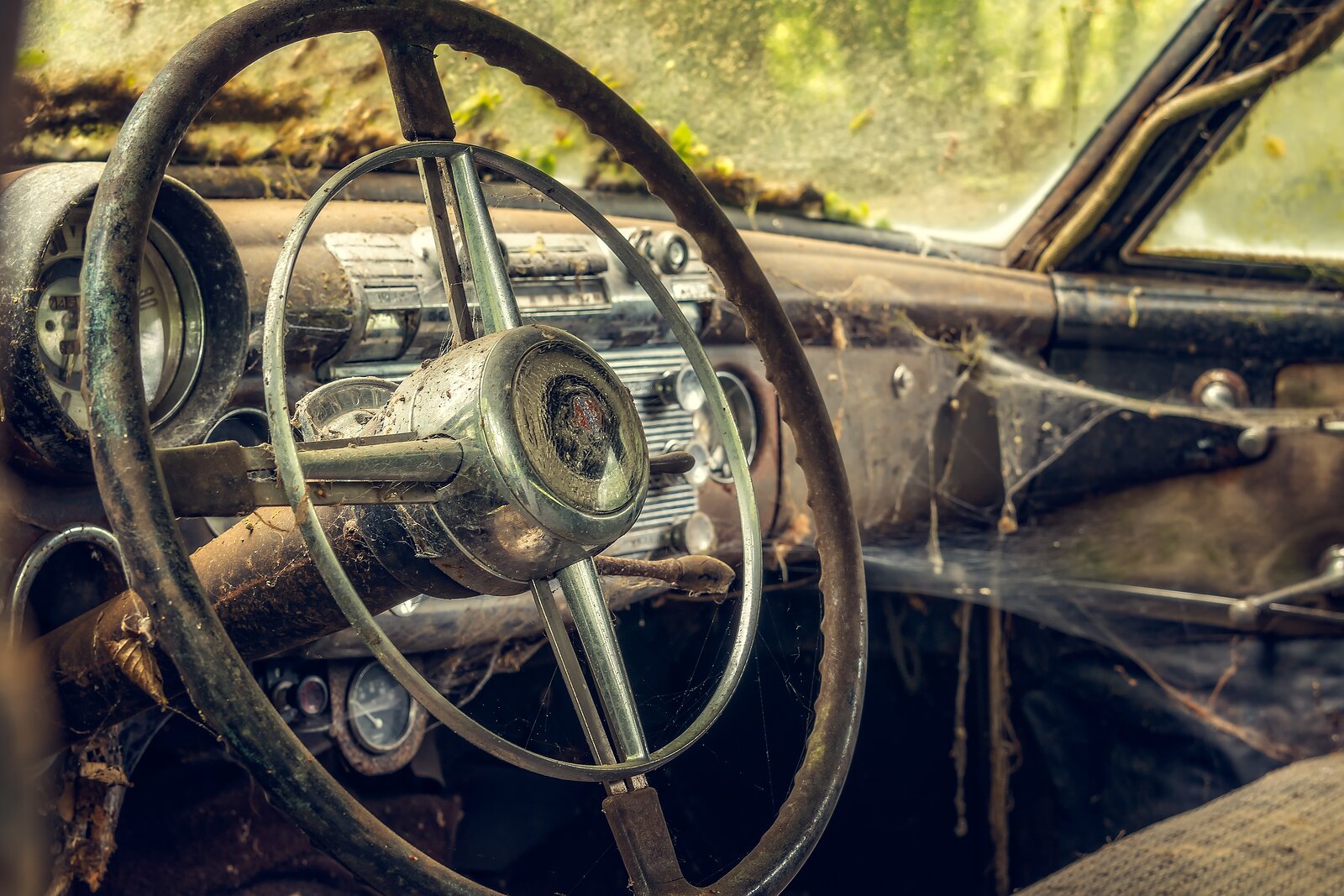 Patinovaný volant a palubní deska opuštěného historického automobilu