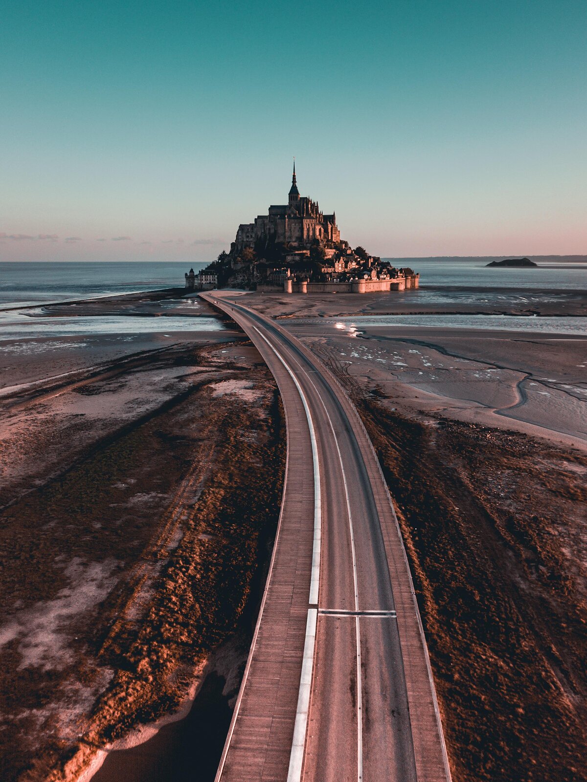 Letecký pohled na Mont Saint-Michel při odlivu se silnicí vedoucí ke klášteru